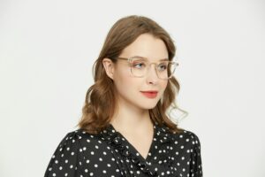 Elegant portrait of a young woman in polka dot shirt and eyeglasses, showcasing contemporary fashion.
